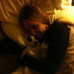 Desiree Capuano, in bed, being affectionate with her dog